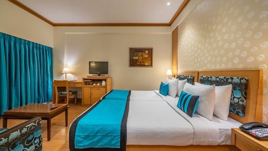 side view of twin beds with white and blue linen in the Executive Room - Kenilworth Hotel, Kolkata