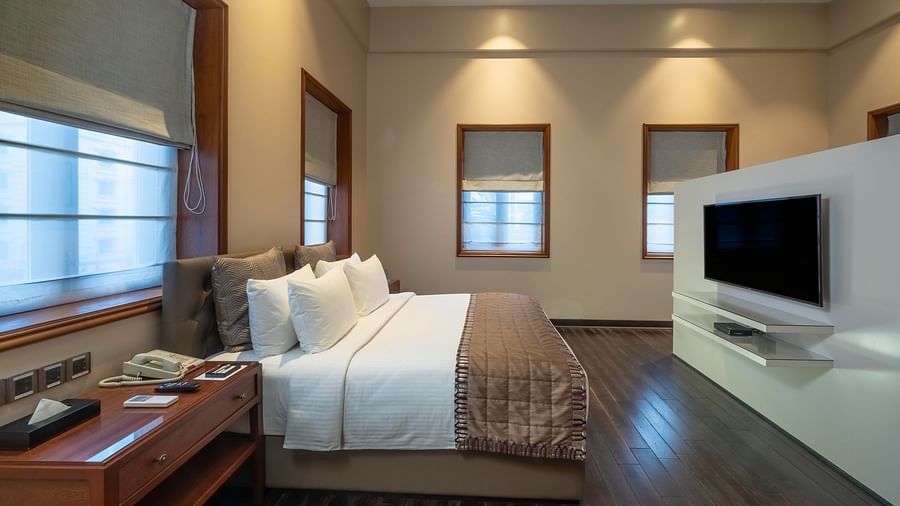 side view of the bed with a television in front at the Premier Club Room - Kenilworth Hotel, Kolkata
