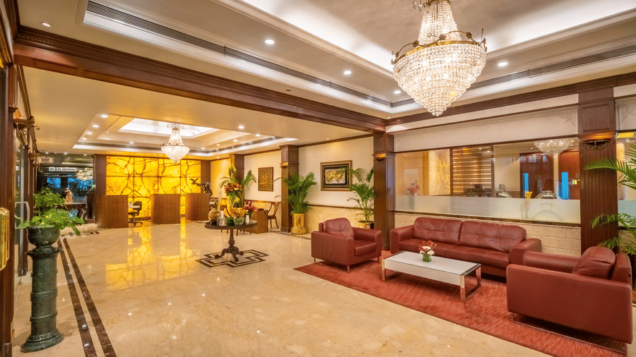 Lobby at Kenilworth Hotel, our luxury hotel in Kolkata, with seating spaces under warm lighting