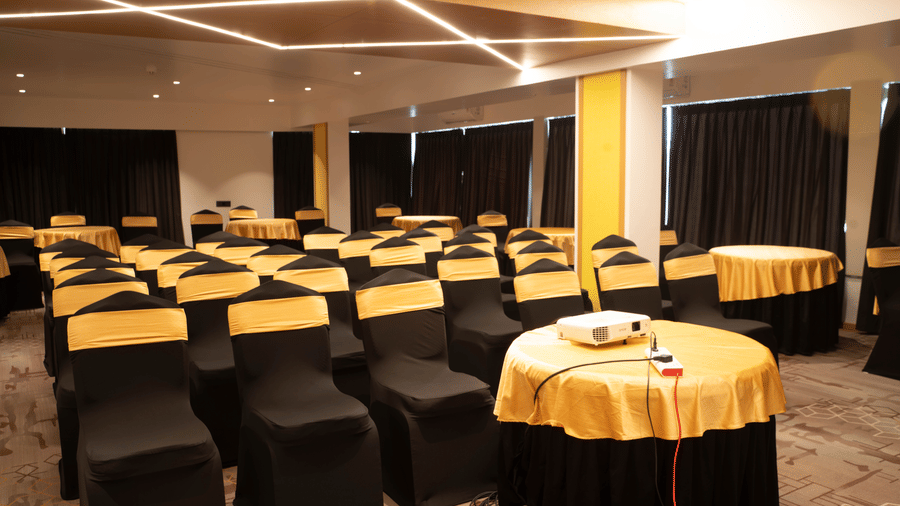 Banquet hall at Magnus Lxia Premier, Kalyani Nagar with round table setup and modern ceiling lighting.