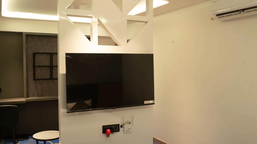 Modern guest room at Magnus Lxia Premier, Kalyani Nagar with wall-mounted TV, workspace, and contemporary interiors.