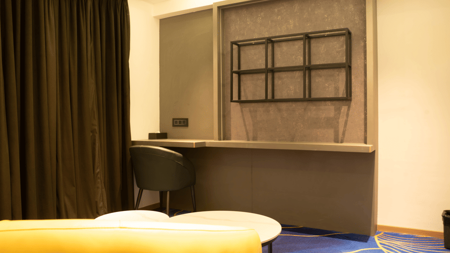 Guest room workspace at Magnus Lxia Premier, Kalyani Nagar with desk, seating, and warm lighting.