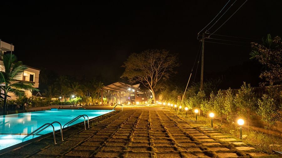 A pathway with grass and stone next to the swimming pool in the night - Mastiff Select Terrain