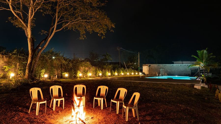 Empty chair in front of a campfire with the swimming pool in the background - Mastiff Select Terrain