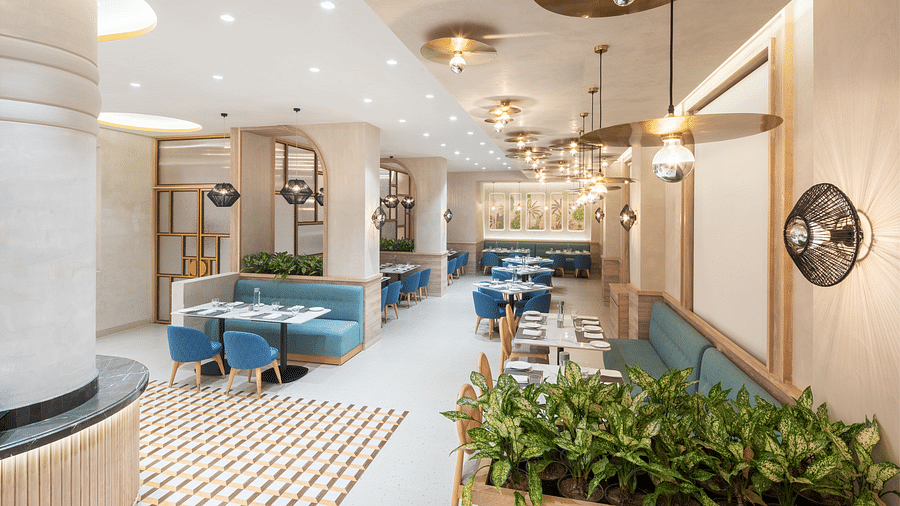 A restaurant interior with a long dining table and a plant wall.
