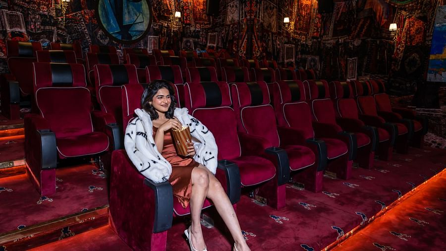 A person enjoying a movie in our private theatre with popcorn in hand  - The Manor Luxury Hotel, Shimla
