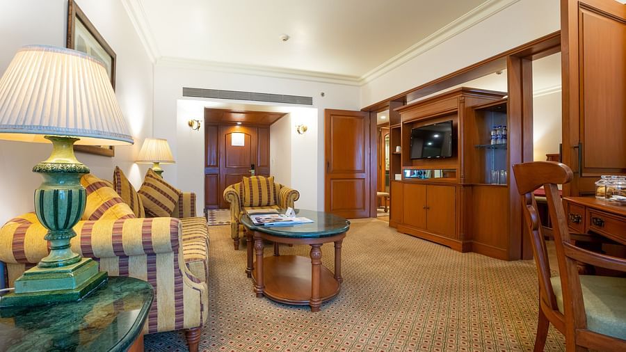 orchid suite living room with a comfy sofa and wooden interiors - The Orchid Hotel Mumbai Vile Parle