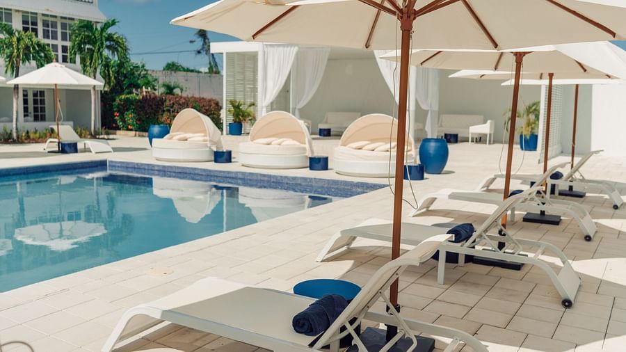 Soco House - a side view of the swimming pool with pool seats lined on the side 1