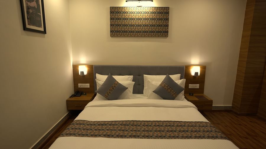  A front view of a bed that is flanked with bed lamps in a room | Voyage The Royal Retreat