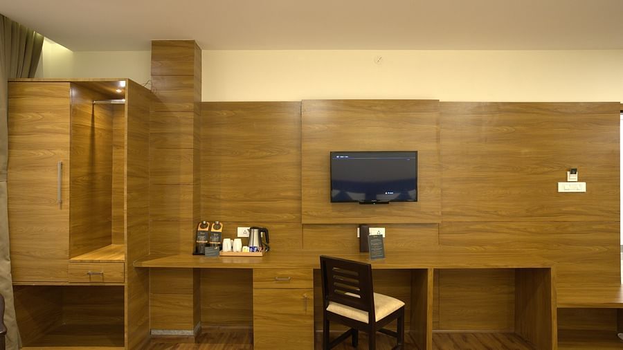 A mirror, work desk, and a TV on the wall | Voyage The Royal Retreat
