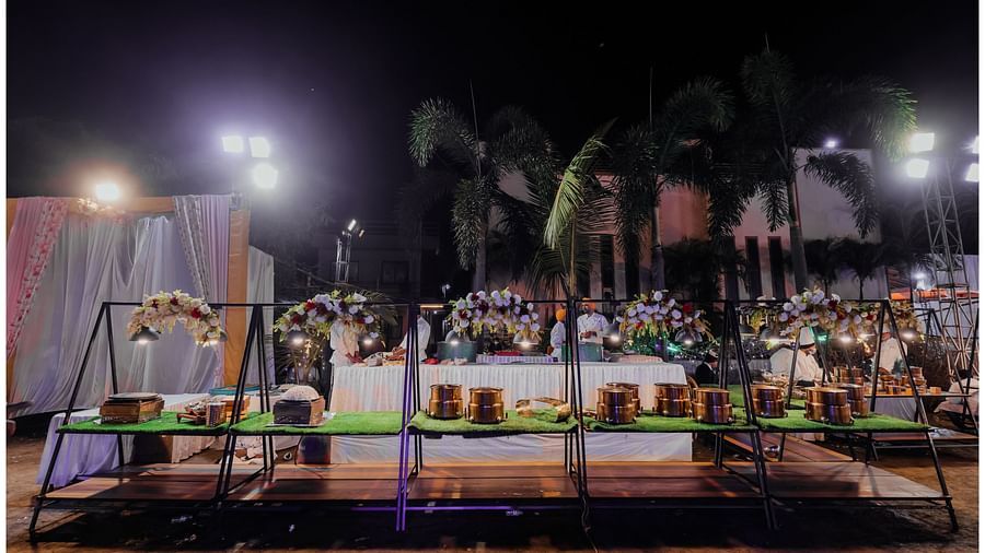 Small boxes neatly arranged on a triangular-shaped table structure in the outdoor venue. - Wedlock Greens Hotel Resorts Dhanbad