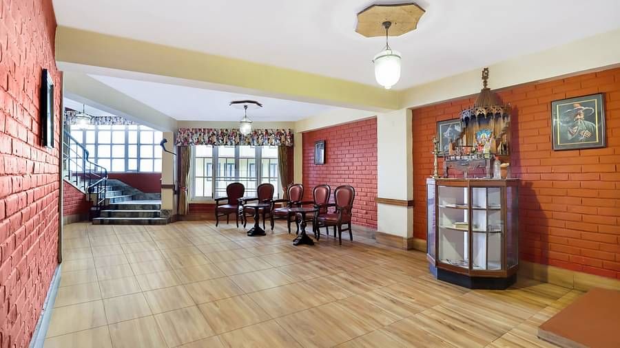 A huge hall that chairs and a staircase that leads to the floor above | Summit Newa Regency & Spa, Pelling
