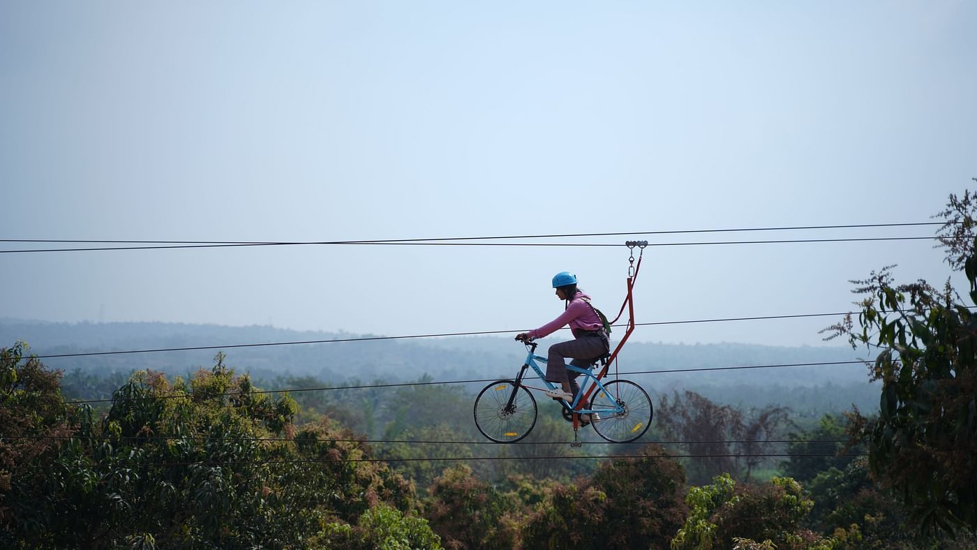 A person on zip cycle at Ravishing Retreat with lush trees in the background