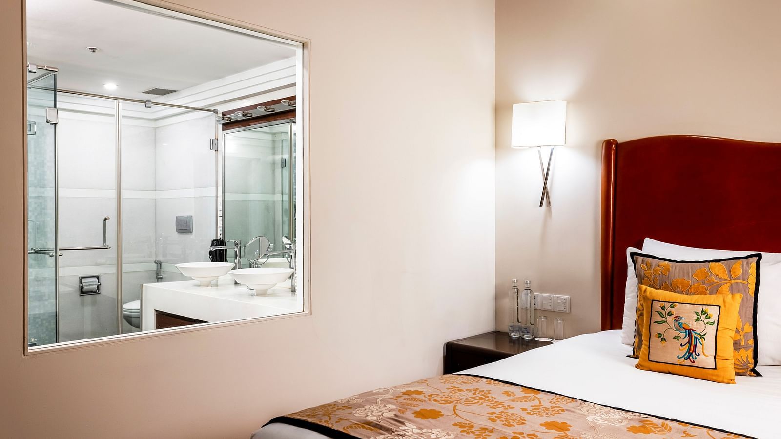 a double bed with side table and lamps inside Deluxe Suite - Caravela Beach Resort Goa