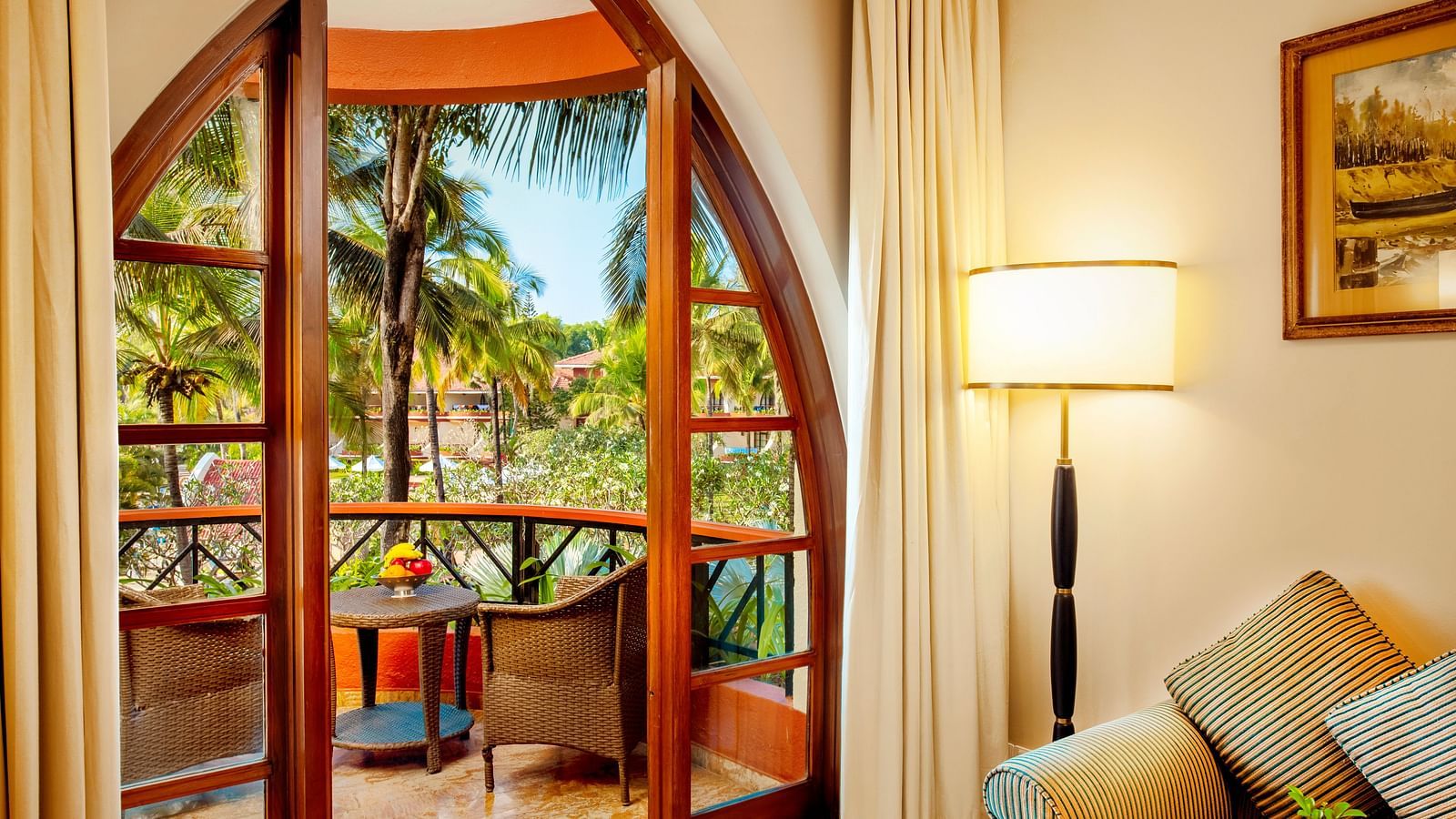 a sofa next to the balcony door inside the Superior Room - Caravela Beach Resort Goa