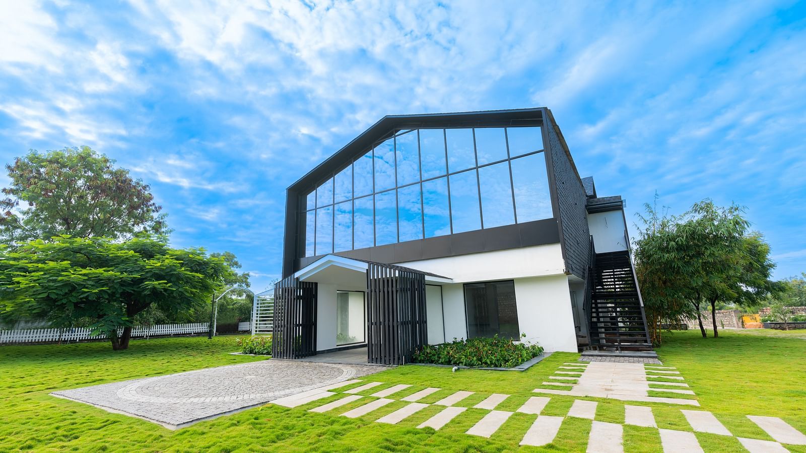 front view image of the facade of the love letter with windows reflecting the clear blue sky - Darza Resorts