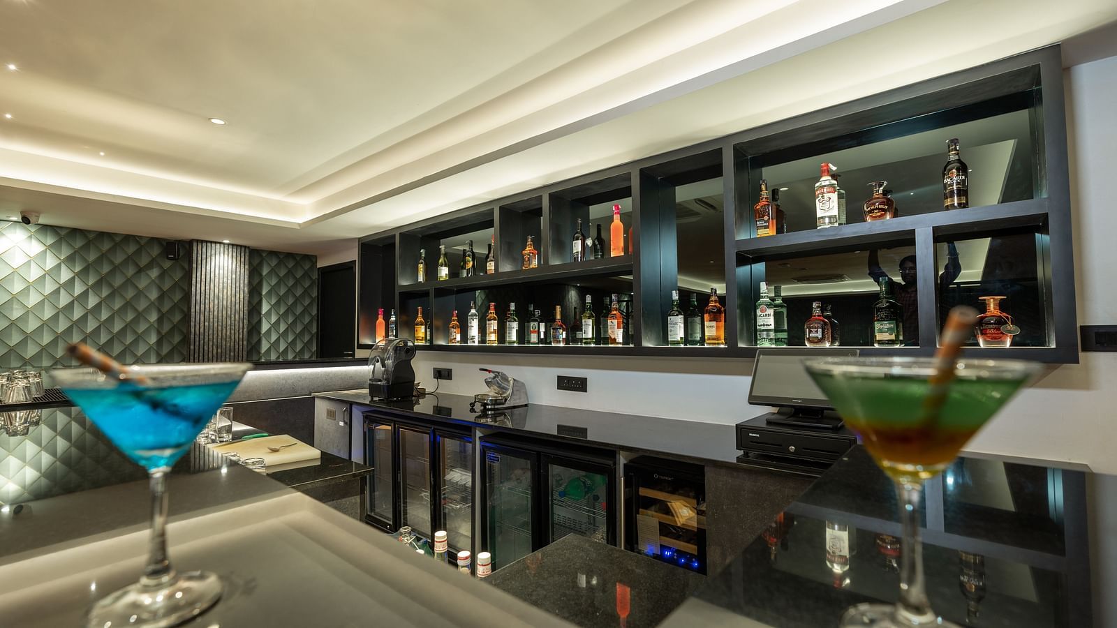 corner view image of the bar at the english club featuring two martini classes with cocktails - Darza Resorts
