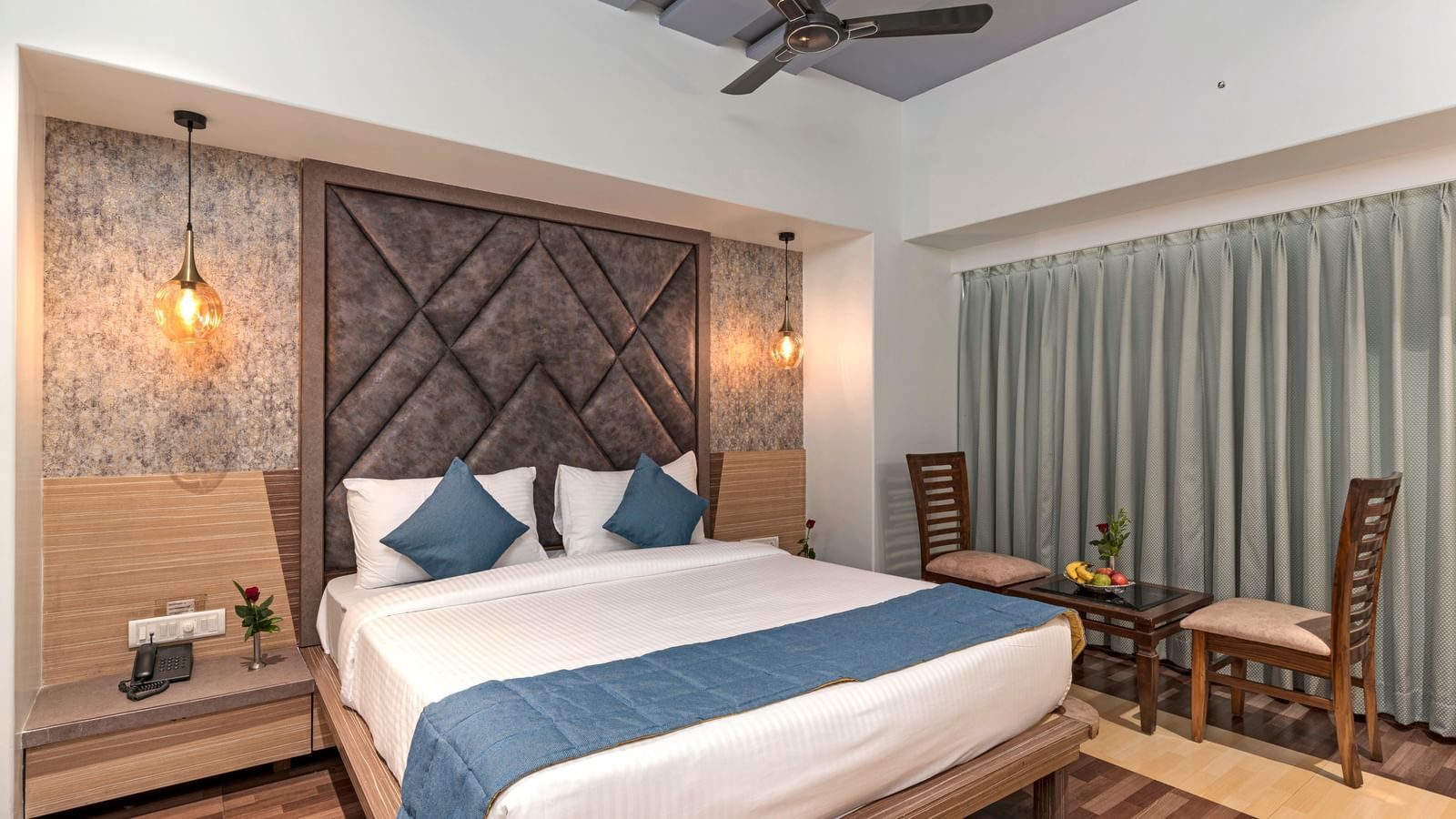 A room at Emerald Retreat, Tungarli with dark wood furnishings, ambient lights, and work desk & chair.