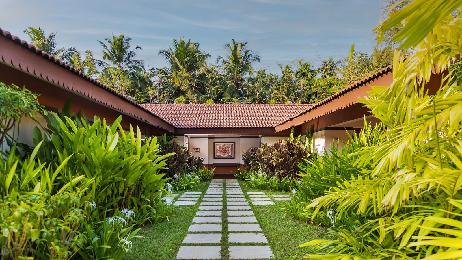 A Cluster of Villas in view with a stoned pathway leading to them - Gamyam Retreat