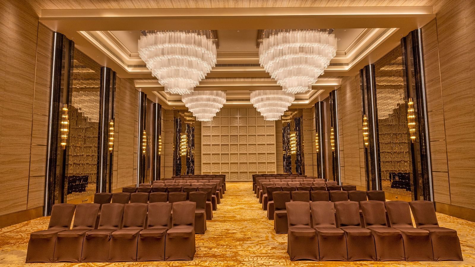 Banquet hall with theatre-style seating arrangement and majestic chandeliers - Grand Madurai by GRT Hotels