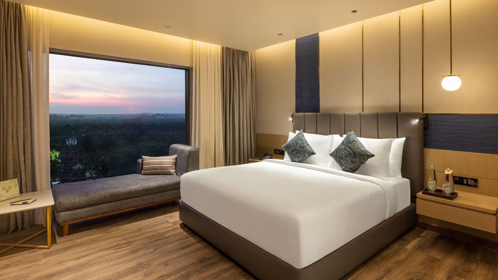 Elegant suite room featuring a comfortable bed and panoramic window views - Grand Madurai by GRT Hotels