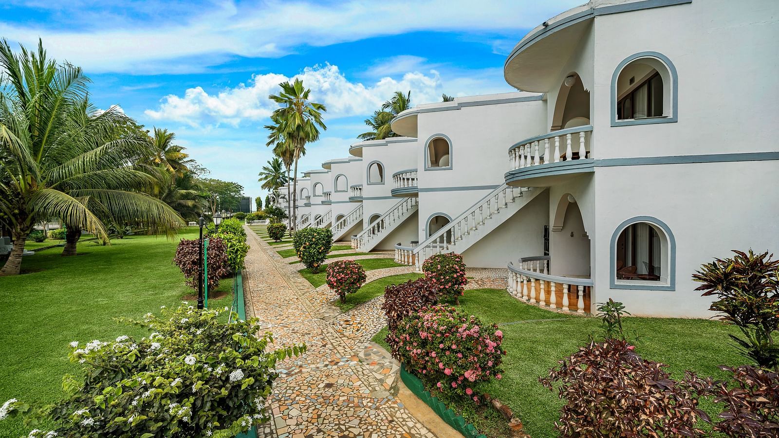 A facade image of a hotel building surrounded by lush greenery - GReaT Trails River View Resort Thanjavur By GRT Hotels