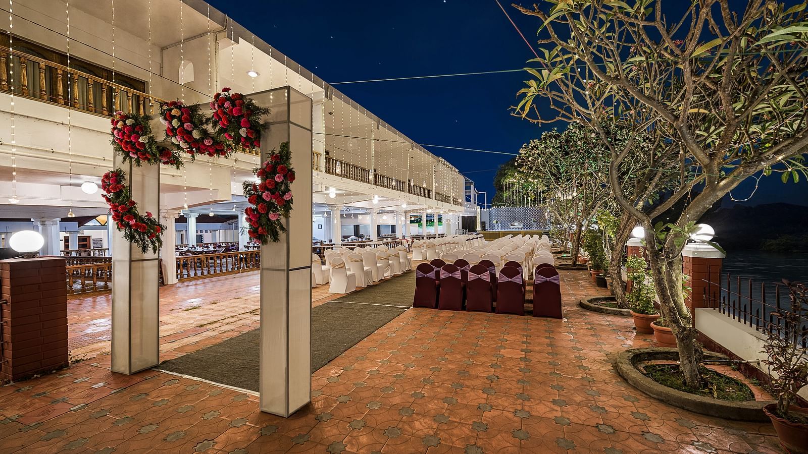 An image of the event hall with seating arrangement and a decorated gate for entrance - GReaT Trails River View Resort Thanjavur By GRT Hotels