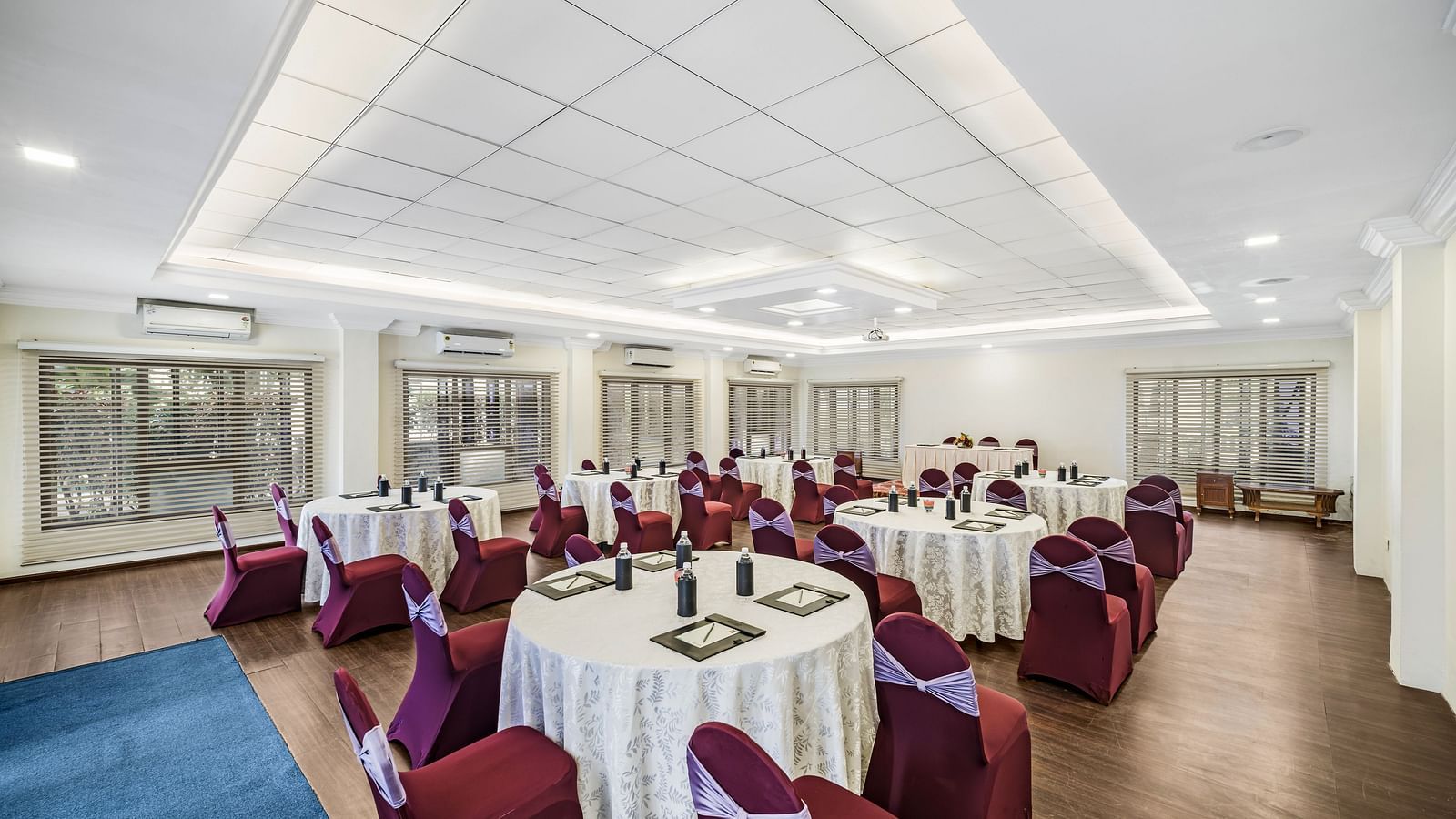 An image of a banquet hall with seating arrangement and bright lighting - GReaT Trails River View Resort Thanjavur By GRT Hotels
