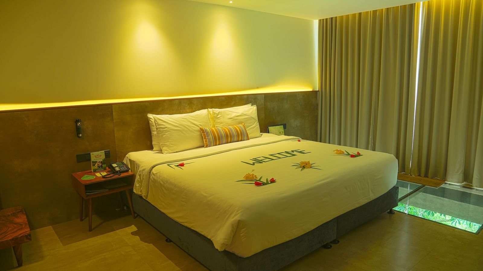 An image of the panorama view room with a king size bed, bed side table, and bright lighting - Great Trails Yercaud by GRT Hotels