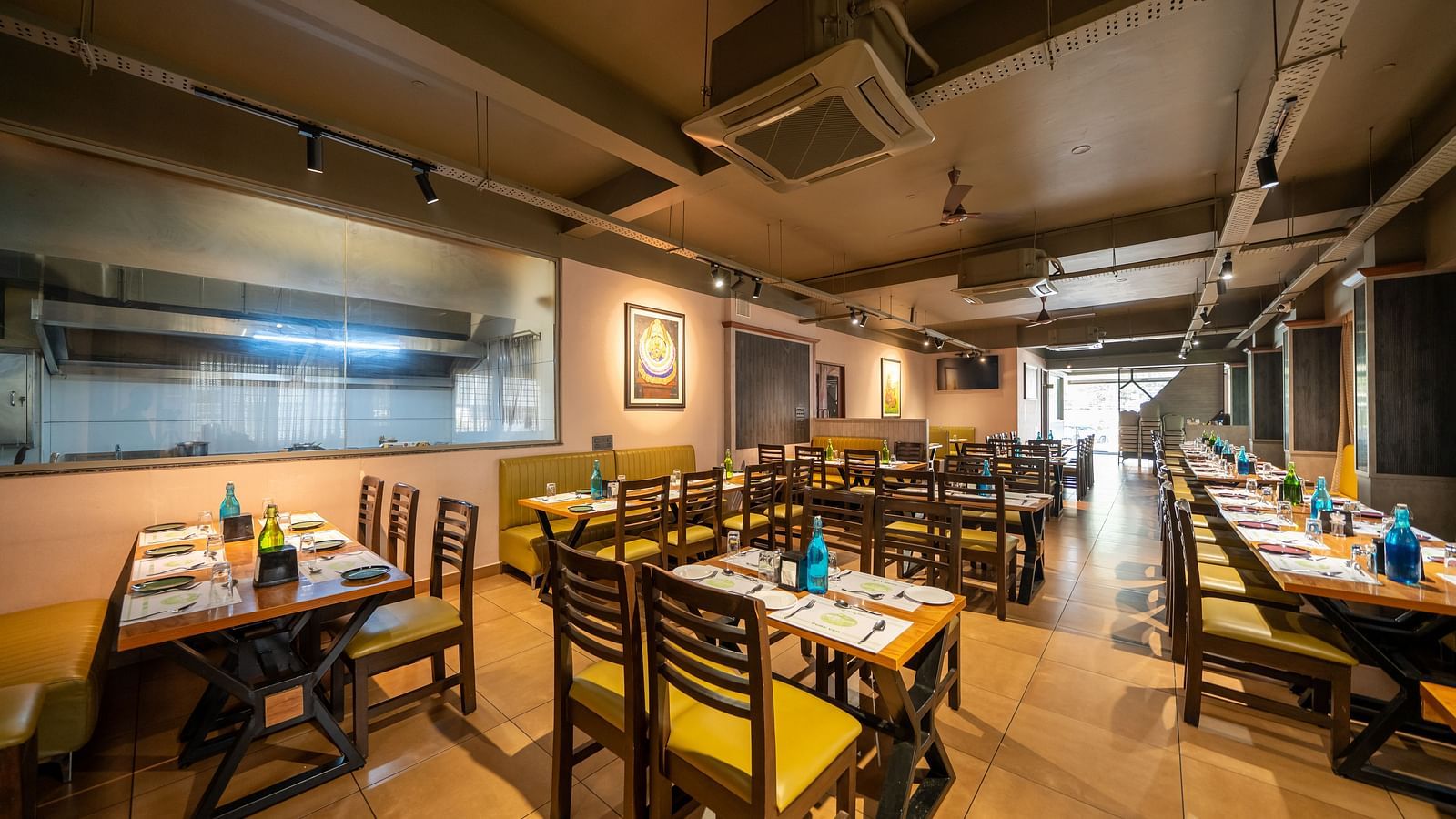 Image of a dining area with tables and chairs arranged around it at Hari Govindas, Siddappa Square.