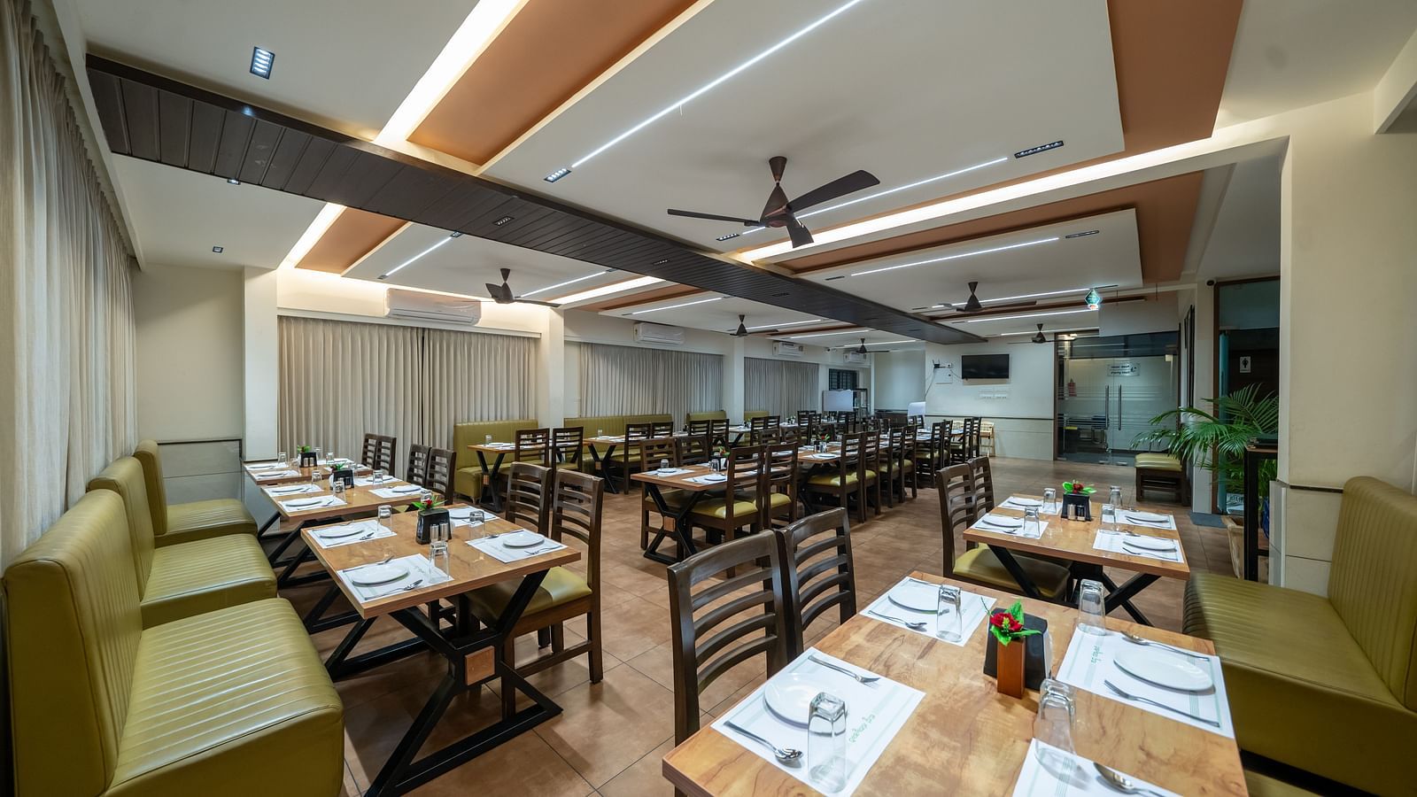 Dining area with close-up view of the neatly set table and chairs kept on both sides of the table at Hari Govinda's
