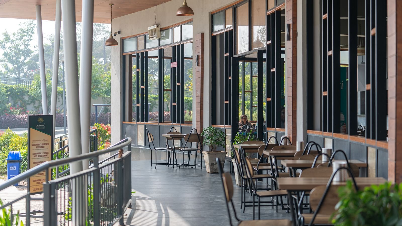 Outdoor dining area at Hari Govinda's, where tables and chairs are set beside the wall