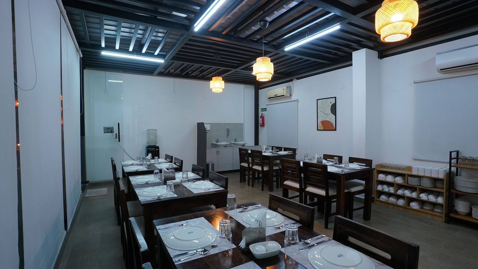 A rooftop dining area with tables and chairs, partially shaded, overlooking a bright outdoor space at Hotel Kyzen Smartstays – Smart, Reliable, Kyzen