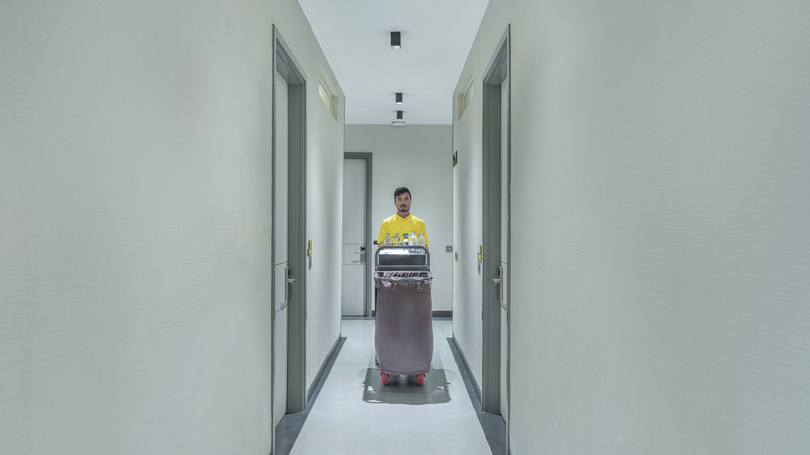 Guest with luggage walking through a hallway of Lime Tree Hotels & Service Apartment Private Limited.