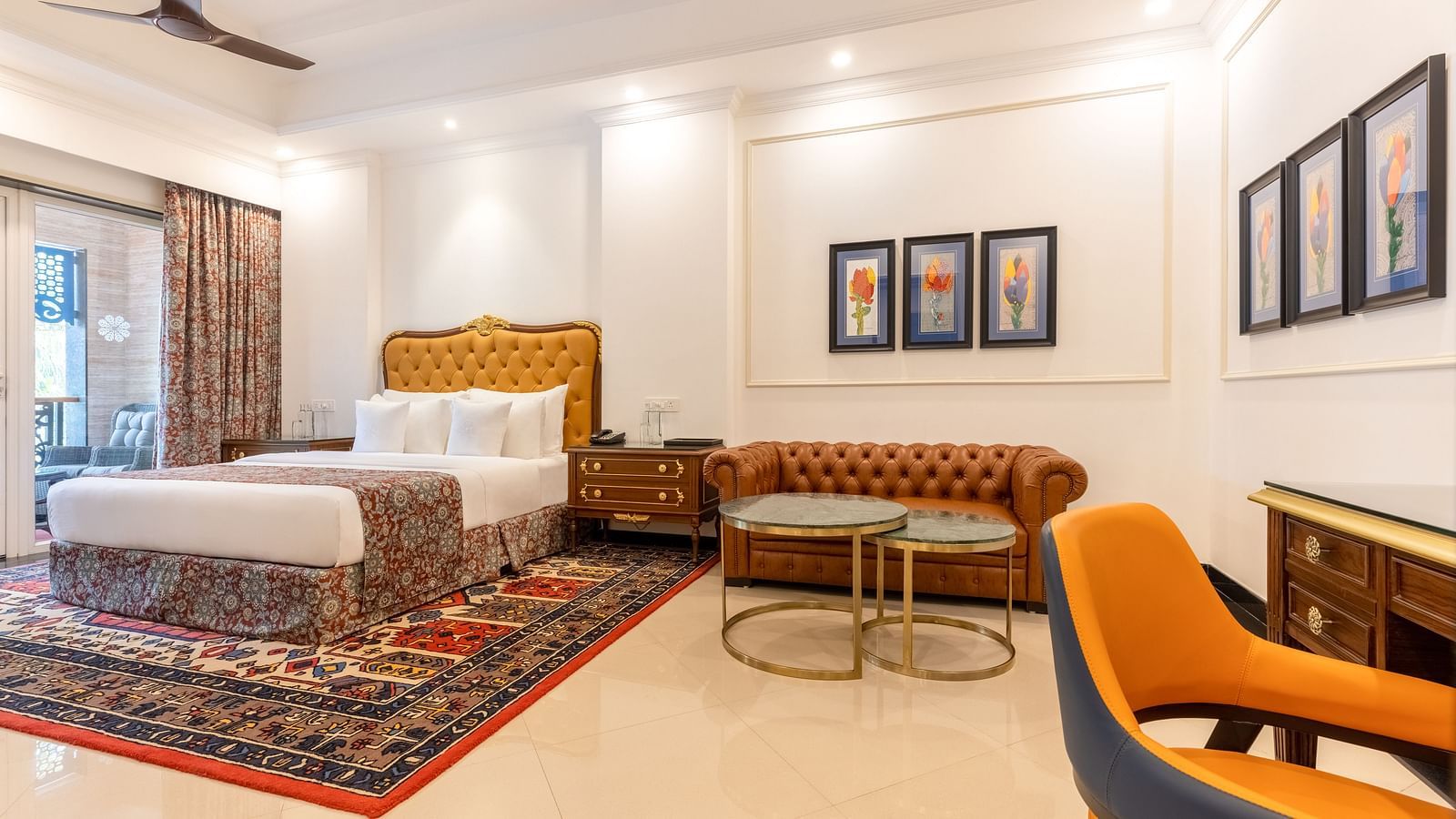 Double bedroom with a seating space, a workstation, ceiling fan, and large Glass windows at MAYFAIR Palm Beach Resort, Gopalpur-On-Sea