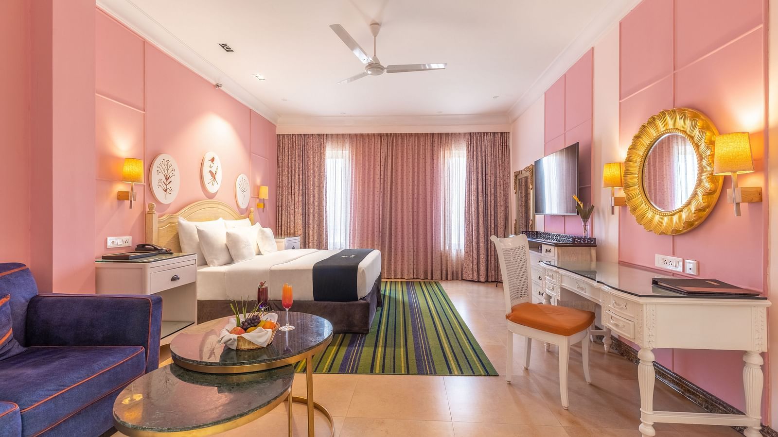 Double bed room with a lounge area, a workstation, large glass windows, and a wall-mounted TV at MAYFAIR Palm Beach Resort, Gopalpur-On-Sea