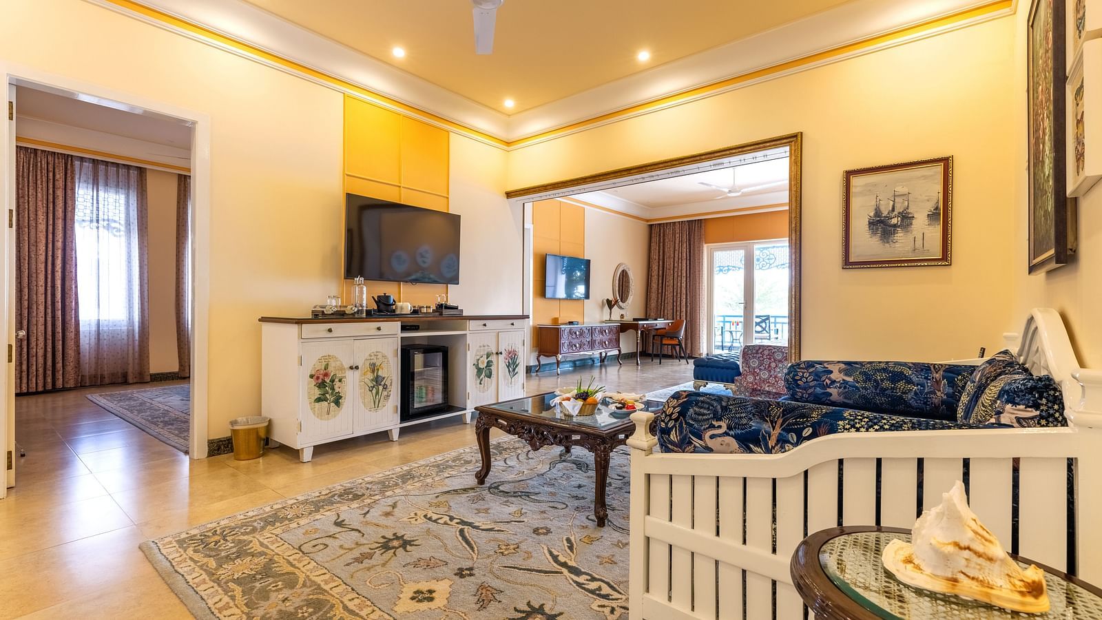 Spacious living area with a sofa set, a coffee table, wall-mounted TV, and separate entrances to different rooms at MAYFAIR Palm Beach Resort, Gopalpur-On-Sea