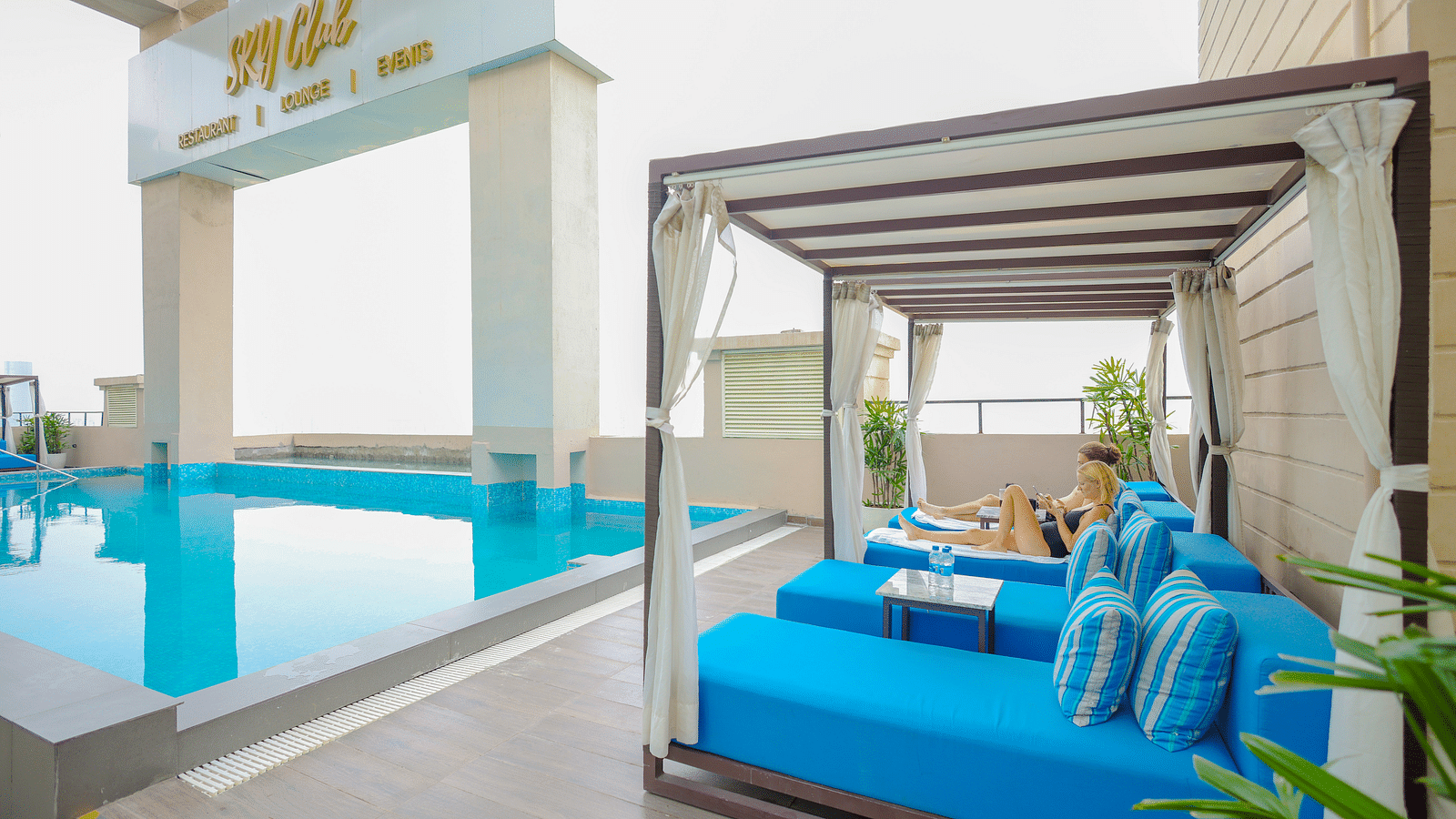 an image of a crystal clear swimming pool with sun decks at Rhythm Gurugram.
