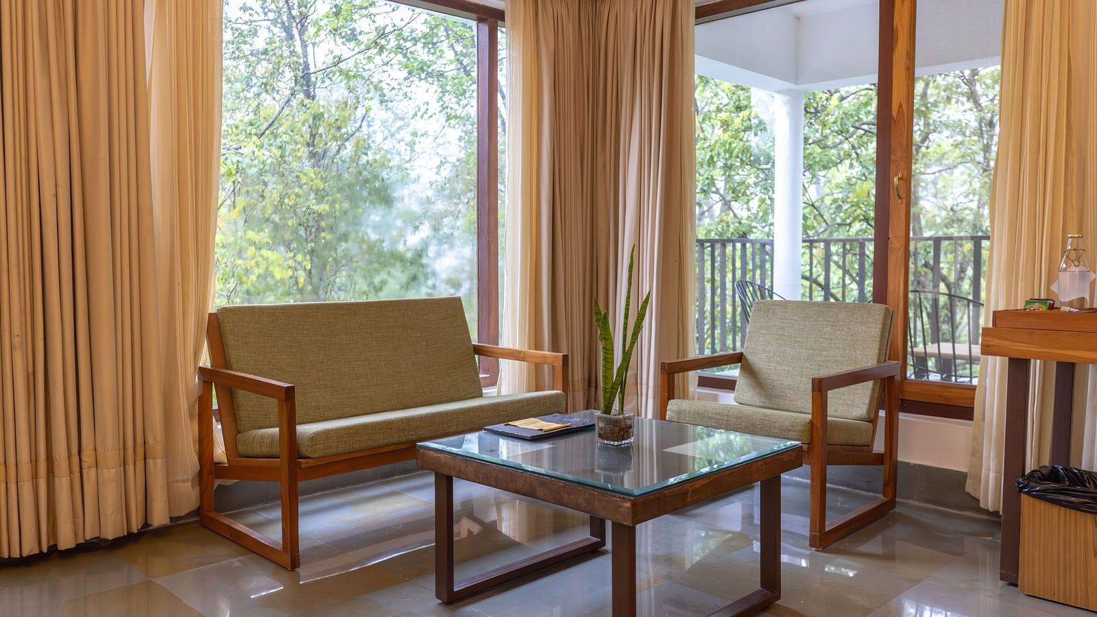 Living area of the Premium Suite at Saraca Resort & Spa Corbett with bench seating and a coffee table 