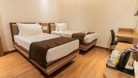 Comfortable twin beds with modern flooring and soft lighting at Beestay Hotels, Rajahmundry.