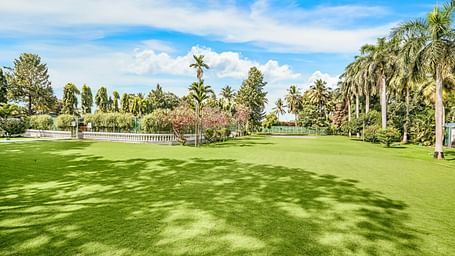 An image of the Vaanam event space which is an outdoor area with lush greenery and beautiful trees - GReaT Trails River View Resort Thanjavur By GRT Hotels
