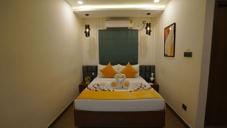 A well-lit bedroom featuring a double bed with a portrait on the wall at Hotel Kyzen Smartstays – Smart, Reliable, Kyzen