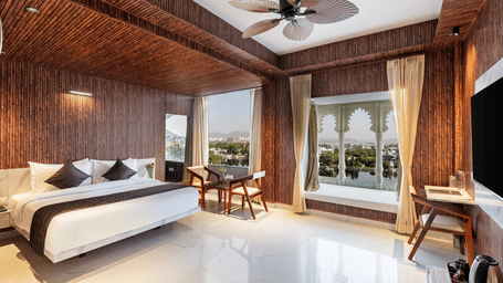 Bright, modern hotel room with a double bed, dark wooden walls, and a large window offering a scenic waterfront view.