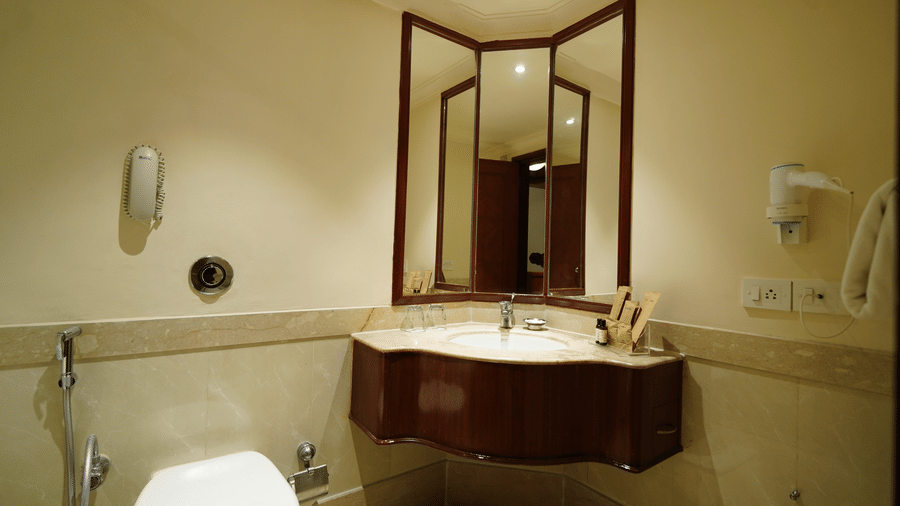 A vanity area in the washroom of Superior Room with a wall-mounted sink and mirror in Accord Metropolitan.