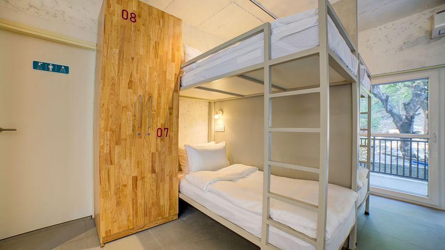 Bunk Beds with a ladder and a window in the back opening into a balcony - Bedzzz, Rishikesh