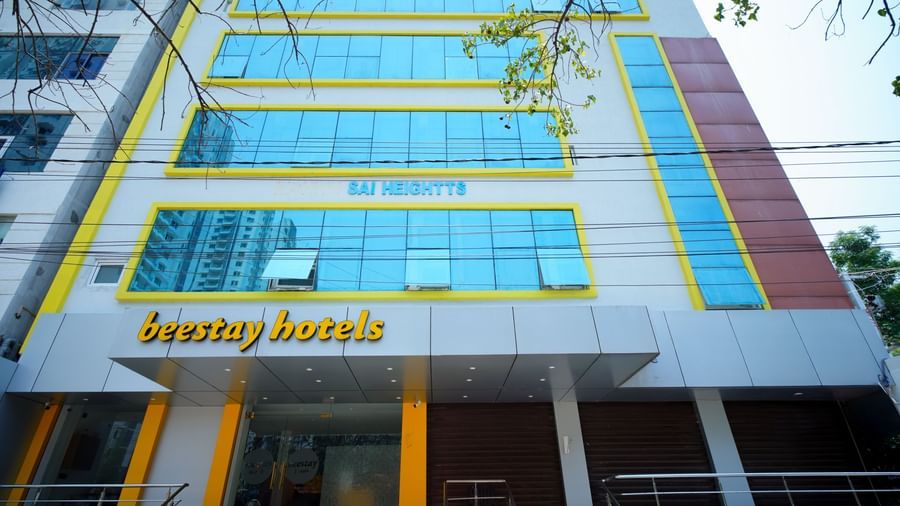 A multi-story building with blue-tinted windows and Beestays Hotels written on the facade - Beestay Hotels Financial District, Hyderabad 