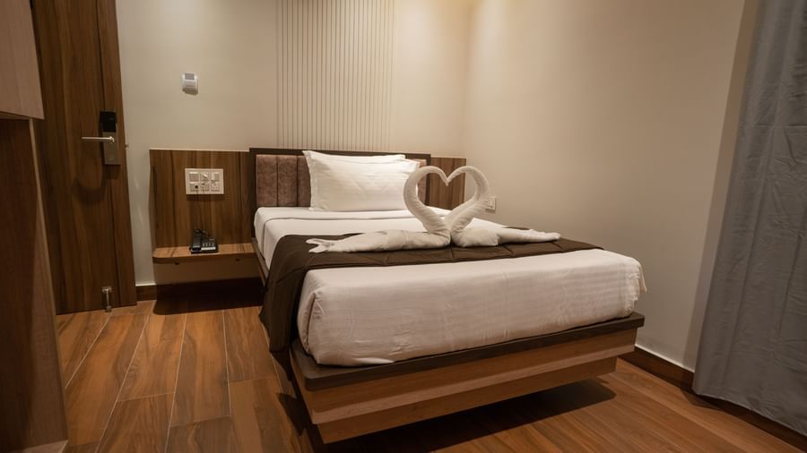 Stylish single bed with bedside table and modern interiors at Beestay Hotels, Rajahmundry.