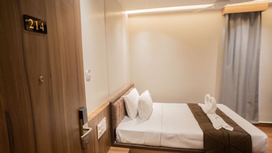 Twin beds with crisp linen and well-lit guest room interiors at Beestay Hotels, Rajahmundry.