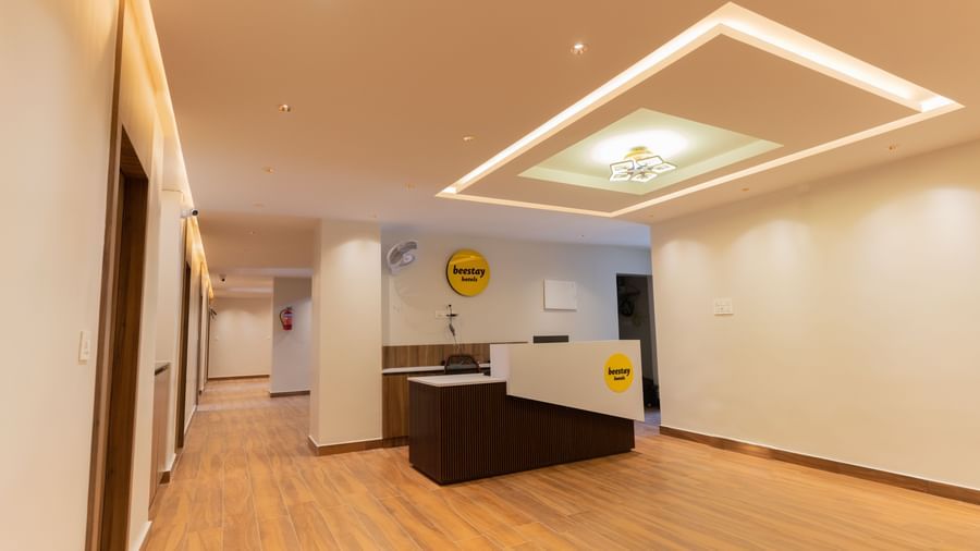 Spacious front desk area with wooden flooring and bright interiors at Beestay Hotels, Rajahmundry.