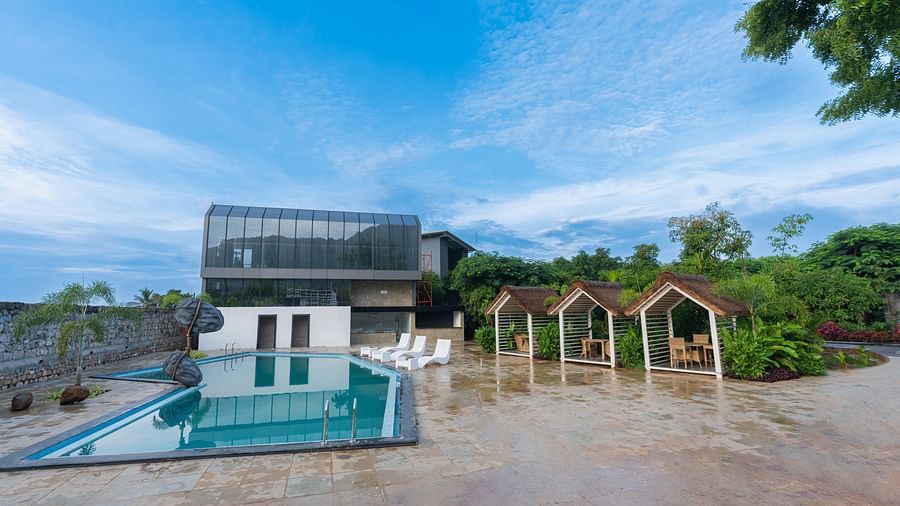 image of the swimming pool with a complex in the background - Darza Resorts